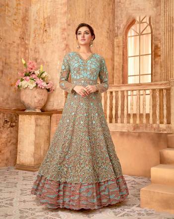 Look Beautiful In This Heavy Designer Floor Length Suit In Beige And Sky Blue Color. Its Is Fabricated On Net Beautified With All Over Heavy Embroidery Which Will Earn You Lots Of Compliments From Onlookers.