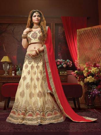 Rich And Elegant Looking Heavy Designer Lehenga Choli Is Here In Cream Color Paired With Contrasting Red Colored Dupatta. Its Blouse Is Fabricated On Art Silk Paired With Jacquard Net Lehenga And Chiffon Fabricated Dupatta. Buy This Designer Piece Now.