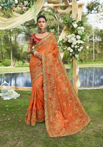 Get Ready For The Upcoming Wedding And Festive Season With This Heavy Designer Saree In Orange Color Paired With Contrasting Red Colored Blouse. This Saree Is Fabricated On Satin Georgette Paired With Art Silk Fabricated Blouse. It Is Beautified With Heavy Embroidery Which Will Give A Glam Look To Your Personality Like Never Before. 