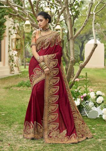 For A Royal And Elegant Look, Grab This Heavy Designer Saree In Maroon Color Paired With Contrasting Peach Colored Blouse. This Lovely Heavy Embroidered Saree Is Fabricated On Soft Silk Paired With Art Silk Fabricated Blouse. 