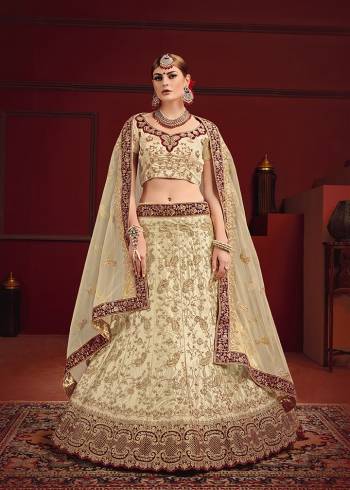 Evergreen And Rich Combination Is Here With This Heavy designer Lehenga Choli In All Cream Color Highlighted With Maroon Colored Lace Borders. Its Blouse And Lehenga Are Satin Based Paired With Net Fabricated Dupatta. It Is Beautified With Heavy Embroidery And Suitable For A Bridal Look.