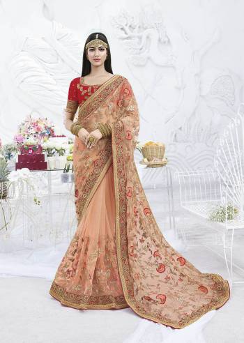 A Must Have Shade In Every Womens Wardrobe Is Here With This Heavy Designer Saree In Peach Color Paired With Contrasting Red Colored Blouse. This Pretty Saree Is Net Based Beautified With Attractive Work Paired With Art Silk Fabricated Blouse. 