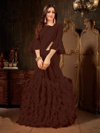 Add This Beautiful Designer Ruffled Saree To Your Wardrobe In Brown Color For The Upcoming Festive And Wedding Season. This Trendy Saree Is Fabricated On Georgette Paired With Art Silk And Georgette Fabricated Blouse. Its Trendy Pattern And Pretty Color Will EArn You Lots Of Compliments From Onlookers. 