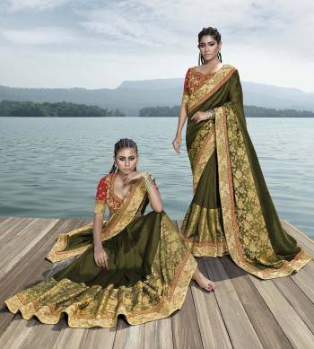 Celebrate This Festive Season Wearing This Designer Saree In Olive Green Color Paired With Contrasting Red Colored Blouse. This Saree Is Fabricated On Fancy Art Silk Which Gives A Rich Look To Your Personality. 