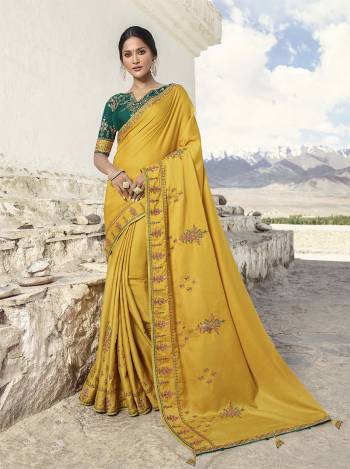 Celebrate This Festive Wearing This Very Pretty And Elegant Looking Designer Saree In Yellow Color Paired With Contrasting Pine Green Colored Blouse. This Saree Is Soft Silk Based paired With Art Silk Fabricated Blouse. 