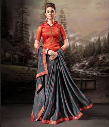 Rich And Elegant Looking Saree Is Here In Dark Grey Color Paired With Contrasting Orange Colored Blouse. This Saree Is Fabricated On Chiffon Paired With Art Silk Fabricated Blouse. Its Fabric Is Light Weight, Durable And Easy To Carry All Day Long. 