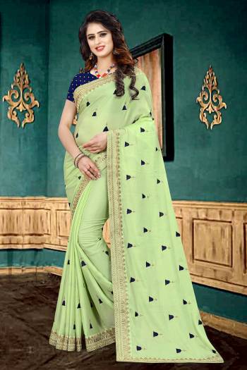 Get Ready For The Upcoming Festive Or Party With This Beautiful Designer Georgette Based Saree In Light Green Color Which Has Lovely Glitter Padding Paired With Contrasting Navy Blue Colored Brocade Blouse. It Is Beautified with Elegant And Subtle Embroidered Lace Border And Butti. 