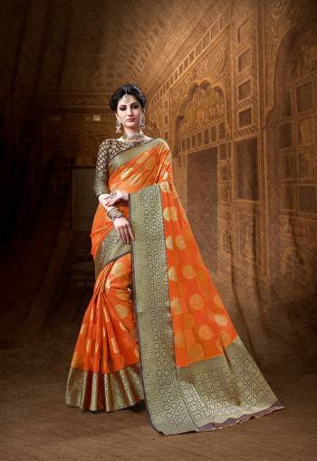 Celebrate This Festive Season Wearing This Designer Silk Based Saree In Orange Color Paired With Contrasting Brown Colored Blouse. It Is Beautified With Weave All Over Giving It Rich And Subtle Look. 