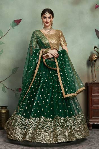 Catch All The Limelight At The Next Wedding You Attend Wearing This Heavy Designer Lehenga Choli In Golden Colored Blouse Paired With Dark Green Colored Lehenga And Dupatta. Its Blouse, Lehenga And Dupatta Are Fabricated On Soft Net Beautified With Attractive Sequence Work. 