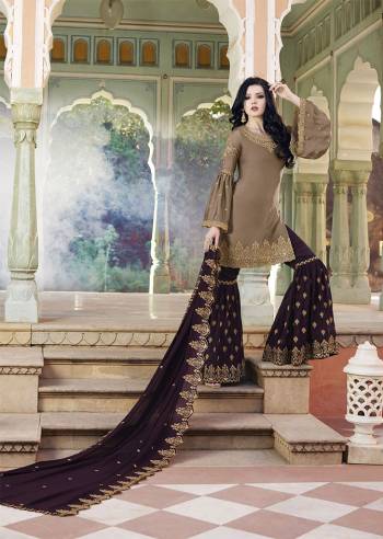 New Color Pallete Is Here With This Designer Sharara Suit In Sand Grey Colored Top Paired With Contrasting Wine Colored Bottom And Dupatta. Its Heavy Embroidered Top And Bottom Are Fabricated On Satin Paired With Embroidered Georgette Fabricated Dupatta.