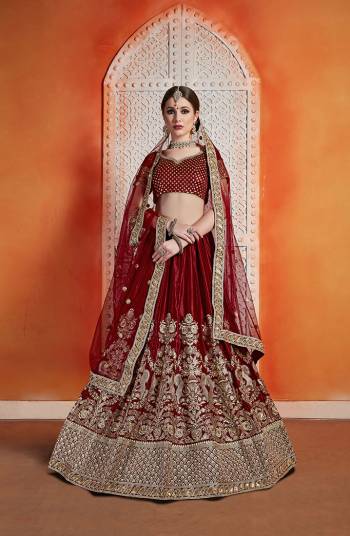 Get Ready For The Upcoming Wedding Season Wearing This Heavy Designer Lehenga Choli In All Over Maroon Color. Its Beautiful Embroiderd Lehenga And Blouse Are Fabricated On Velvet Paired With Net Fabricated Dupatta. 