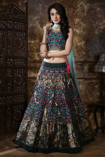 Get Ready For The Upcoming Wedding Season Wearing This Heavy Designer Lehenga Choli In Dark Green Color Paired With Contrasting Aqua Blue Colored Dupatta. This Lehenga Choli Is Silk Based Paired With Net Fabricated Dupatta. It Is Beautified With Multi Colored Prints And Resham Work With Foil Print. 