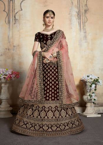 Get Ready For Your D-day With This Heavy Designer Bridal Lehenga?choli In Maroon Color Paired With Contrasting Peach Colored Dupatta. This Velvet Based Lehenga And Choli Are Beautified With Heavy Jari And Resham Embroidery With Stone Work. Its Fabric Also Ensures Superb Comfort Throughout The Gala And Earn You Lots Of Compliments From Onlookers. Buy This Bridal Lehenga Choli Now.