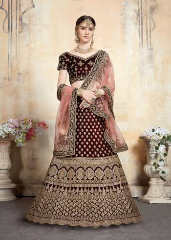 Get Ready For Your D-day With This Heavy Designer Bridal Lehenga?choli In Maroon Color Paired With Contrasting Peach Colored Dupatta. This Velvet Based Lehenga And Choli Are Beautified With Heavy Jari And Resham Embroidery With Stone Work. Its Fabric Also Ensures Superb Comfort Throughout The Gala And Earn You Lots Of Compliments From Onlookers. Buy This Bridal Lehenga Choli Now.