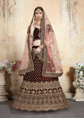 Get Ready For Your D-day With This Heavy Designer Bridal Lehenga?choli In Maroon Color Paired With Contrasting Peach Colored Dupatta. This Velvet Based Lehenga And Choli Are Beautified With Heavy Jari And Resham Embroidery With Stone Work. Its Fabric Also Ensures Superb Comfort Throughout The Gala And Earn You Lots Of Compliments From Onlookers. Buy This Bridal Lehenga Choli Now.