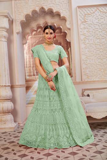 This Wedding Season Be The Most Sensational Diva Wearing This Heavy Designer Lehenga Choli In Mint Green Color. This Pretty Blouse, Lehenga And Dupatta Are Fabricated On Net Beautified With Tone To Tone Coding And Resham Embroidery With Stone Work. Buy This Designer Piece Now.