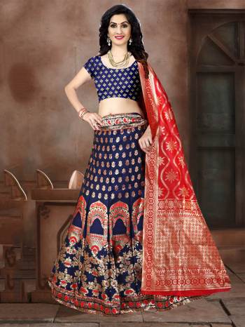 This Festive Season Have A Proper Traditional Look Wearing This Silk Based Lehenga Choli In Navy Blue Color Paired With Contrasting Red Colored Dupatta. This Lehenga Choli Is Fabricated On Banarasi Jacquard Silk Beautified With Weave All Over. 