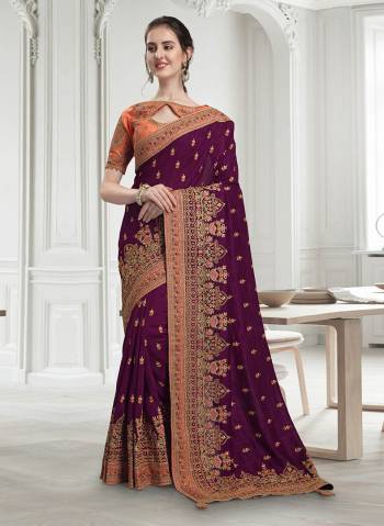 Look The Most Attractive Of All Wearing This Heavy Designer Saree In Wine Color Paired With Contrasting Orange Colored Blouse. This Saree And Blouse Are Silk Based Beautified With Heavy Detailed Embroidery Which Will Earn You Lots Of Compliments From Onlookers. 