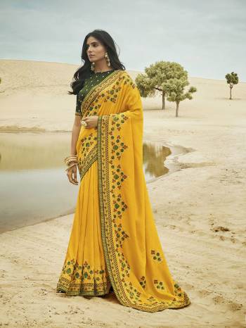 Celebrate This Festive And Wedding Season Wearing This Very Beautiful Heavy Designer Saree In Yellow Color Paired With Contrasting Green Colored Blouse. This Saree And Blouse Are Silk Based Beautified Detailed Attractive Embroidery. 