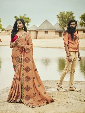 A Must Have Shade In Every Womens Wardrobe Is Here With This Designer Saree In Peach Color Paired With Contrasting Red Colored Blouse. This Saree And Blouse are Silk Based Beautified With Contrasting Embroidery All Over. 