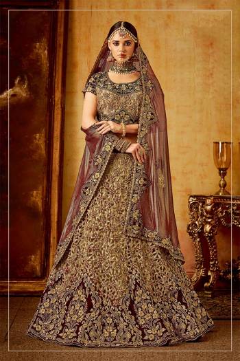 Get Ready For Your D-Day With This Heavy Designer Bridal Lehenga?Choli In Maroon And Beige Color Paired With Maroon Colored Dupatta. Its Heavy Embroidered Blouse And Lehenga Are Fabricated On Velvet Paired With Net Fabricated Dupatta