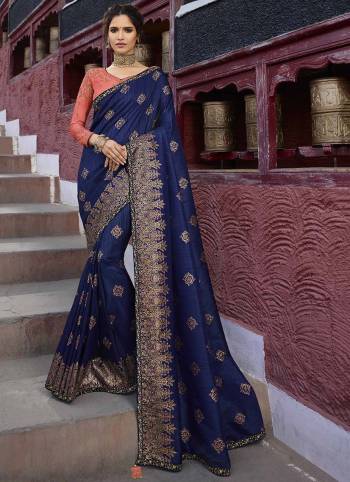 Enhance Your Personality Wearing This Heavy Designer Saree In Navy Blue Color Paired With Contrasting Orange Colored Blouse. This Heavy Embroidered Saree Is Fabricated On Weaving Art Silk Paired With Art Silk Fabricated Blouse. It Is Beautified With Detailed Weave And Heavy Embroidery. 