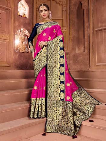 Bright And Visually Appealing Color Pallete Is Here With This Designer Saree In Rani Pink Color Paired With Contrasting Navy Blue Colored Blouse. This Saree And Blouse Are Silk based Beautified With Weave All Over. 