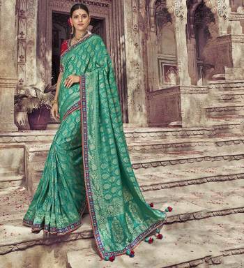 Celebrate This Festive Season Wearing This Designer Saree In Sea Green Color Paired With Contrasting Red Colored Blouse. This Saree And Blouse Are Silk Based Beautified With Weave And Embroidery. Buy Now.