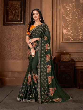 Celebrate This Festive Season with Beauty And Comfort Wearing This Light Weight Georgette Based Saree In Dark Green Color Paired With Orange Colored Art silk fabricated Blouse. 