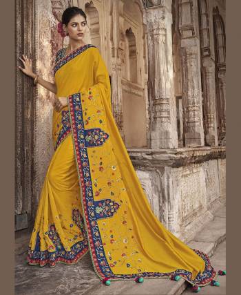 Catch All The Limelight At The Next Wedding You Attend Wearing This Heavy Designer Saree In Yellow Color Paired With Contrasting Navy Blue Colored Blouse. This Saree And Blouse Are Silk Based Beautified With Heavy Embroidery. 