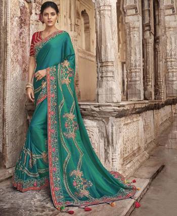 New Shade IS Here To Add Into Your Wardrobe With This Heavy Designer Saree In Teal Green Color Paired With Contrasting Red Colored Blouse. This Saree And Blouse Are Silk Based Beautified With Heavy Amnd Attractive Embroidery. 