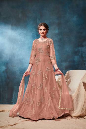 This Wedding & Festive Season, Grab This Heavy Designer Floor Length Suit In Dusty Peach Color. Its Embroidered Top Is Fabricated On Net Paired With Santoon Bottom And Net Fabricated Dupatta. Buy Now.