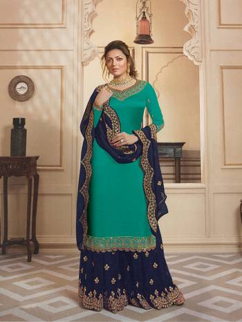 Go With The Shades Of Blue Wearing This Heavy Designer Sharara Suit In Turquoise Blue Colored Top And Bottom Paired With Navy Blue Colored Sharara And Dupatta. Its Top Is Fabricated On Satin Georgette Paired With Santoon Bottom, Georgette Fabricated Sharara And Dupatta. Buy Now.