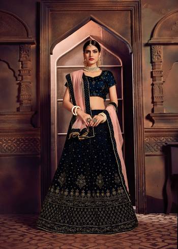 You Will Definitely Earn Lots Of Compliments In This Elegant Looking Designer Lehenga Choli In Navy Blue Color Paired With Peach Colored Dupatta. This Beautiful Lehenga Choli Is Fabricated On Velvet Paired With Net Fabricated Dupatta. It Is Beautified With Attractive Stone Work All Over. 