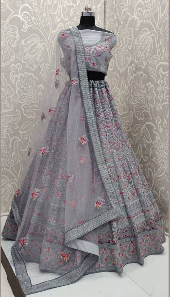 This Wedding Season, Look The Most Graceful Of All Wearing This Heavy Designer Lehenga Choli In Grey Color. Its Blouse, Lehenga And Dupatta are Fabricated on Net Beautified With Tone To Tone Coding Work And Contrasting Resham Embroidery With Stone Work. Buy Now.