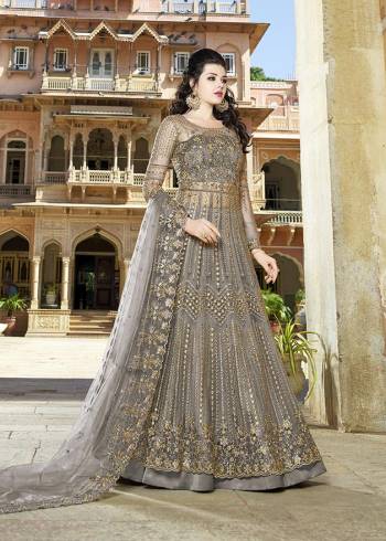 Here Is An Elegant Girly Shade With This Heavy Designer Floor Length Suit In Dark Grey Color. Its Top And dupatta are Net Based Beautified With Heavy Embroidery Paired With Satin Fabricated Bottom. 