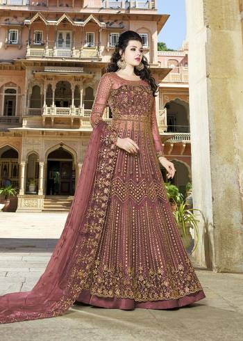 Here Is An Elegant Girly Shade With This Heavy Designer Floor Length Suit In Onion Pink Color. Its Top And dupatta are Net Based Beautified With Heavy Embroidery Paired With Satin Fabricated Bottom. 