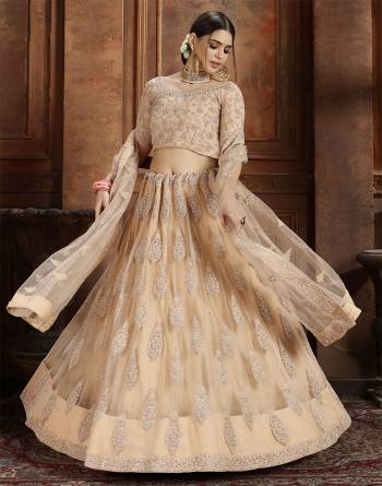 Get Ready For The Upcoming Wedding Season With This Very Beautiful Heavy Designer Lehenga Choli In Beige Color. Its Heavy Embroidered Blouse, Lehenga And Choli Are Fabricated On Net Which Is Light In Weight And Easy To Carry Throughout The Gala. 