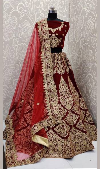 Here Is A Beautiful Designer Bridal Lehenga Choli In Maroon Color Paired With Red Colored Dupatta. This Beautiful Heavy Lehenga Choli Is Fabricated On Velvet Paired With Net Fabricated Dupatta. It Is Beautified With Heavy Detailed Embroidery. Get Ready For Your D-Day With This Designer Piece And Look The Most Graceful Of All. 