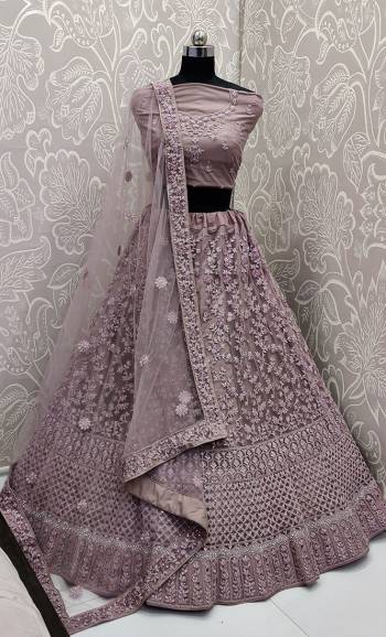 This Wedding Season, Look The Most Graceful Of All Wearing This Heavy Designer Elegant Lehenga Choli In Mauve Color. Its Blouse, Lehenga And Dupatta are Fabricated on Net Beautified With Tone To Tone Coding And Resham Embroidery With Stone Work. Its Pretty Elegant Color And Tone-To-Tone Work Will Definitely Earn You Lots Of Compliments From Onlookers. 