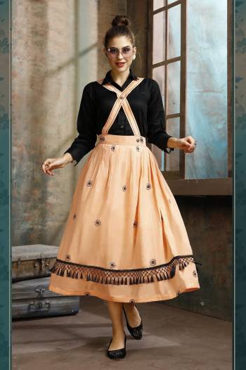 Grab This Pretty Two-Piece Readymade Dress Which Has A Black Colored Shirt Paired With A Dungaree Dress In Light Orange Color. The Shirt Is Fabricated on Rayon Paired With Cotton Based Over Dress. It Is Light In Weight And Easy To Carry All Day Long. 