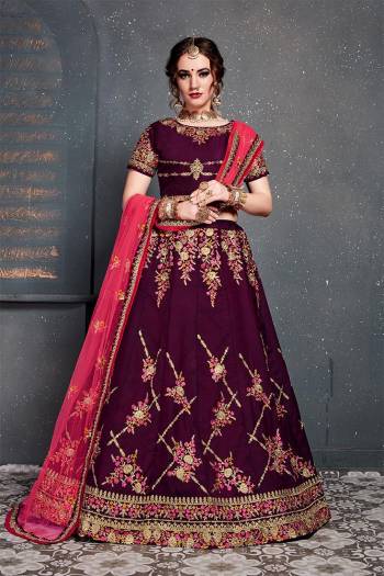 Grab This Heavy Designer Lehenga Choli For This Wedding Season In Wine Color Paired With Contrasting Dark Pink Colored Dupatta. This Pretty Lehenga Choli Is Satin Silk Based Paired With Net Fabricated Dupatta. Buy This Piece Now.