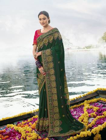 Add This Very Beautiful And Heavy designer Saree In Dark Green Color Paired With Contrasting Rani Pink Colored Blouse. This Saree Is Silk Based Paired With Chinon Fabricated Blouse. It Is Beautified With Heavy Embroidery Giving You An Attractive Look. 