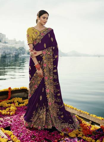 Catch All The Linelight At The Next Wedding You Attend In This Very Beautiful And Heavy Designer Saree In Dark Purple Color Paired With Contrasting Musturd Yellow Colored Blouse. This Saree And Blouse Are Silk Based Beautified With Detailed Heavy Embroidery. 