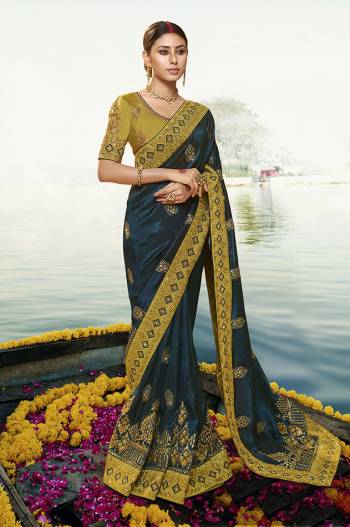 Add This Very Beautiful And Heavy designer Saree In Teal Blue Color Paired With Contrasting Olive Green Colored Blouse. This Saree Is Silk Based Paired With Art Silk Fabricated Blouse. It Is Beautified With Heavy Embroidery Giving You An Attractive Look. 