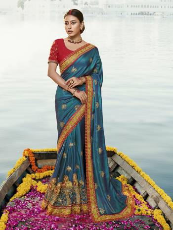 Catch All The Linelight At The Next Wedding You Attend In This Very Beautiful And Heavy Designer Saree In Blue Color Paired With Contrasting Red Colored Blouse. This Saree And Blouse Are Silk Based Beautified With Detailed Heavy Embroidery. 