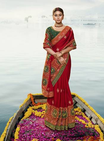 Attract All Wearing This Heavy Designer Saree In Red Color Paired With Contrasting Dark Green Colored Blouse. This Saree And Blouse Are Silk Based Beautified With Heavy Embroidery All Over. 