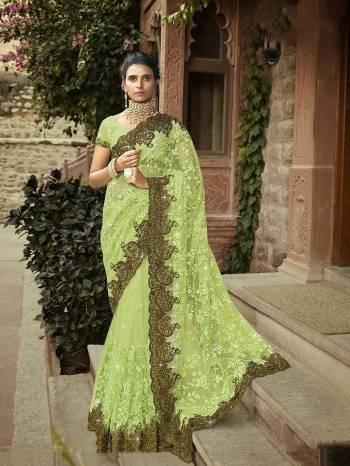 You Will Definitely Earn Lots Of Compliments Wearing This Heavy Designer Saree In Light Green Color Paired With Light Green Colored Blouse. This Heavy Embroidered Saree Is Fabricated On Net Paired With Georgette Fabricated Embroidered Blouse. 