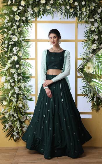 You Will Definitely Earn Lots Of Compliments Wearing This Designer Lehenga Choli In Pine Green Color Paired With Contrasting Aqua Blue Colored Peplum Jacket. This Lehenga Choli IS Fabricated on Muslin Paired With Georgette Fabricated Jacket, Its Fabrics Are Soft Towards Skin And Ensures Superb Comfort all Day Long. 