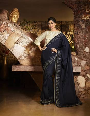 Enhance Your Personality Wearing This Designer Saree In Navy Blue Color Paired With Elegant Cream Colored Blouse. This Saree Is Fabricated On Soft Silk Beautified With Minimal Embroidery Over The Border Paired With Satin Silk Fabricated Blouse. Buy This Saree Now. 
